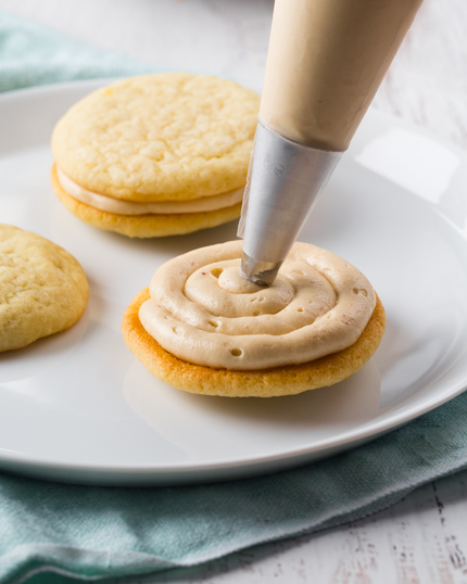 Glaçage au beurre noisette se faisant appliquer à la douille sur des biscuits