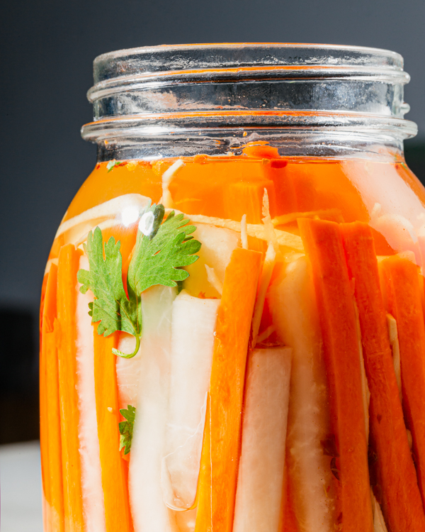 Un bocal de carottes et de radis daikon marinés