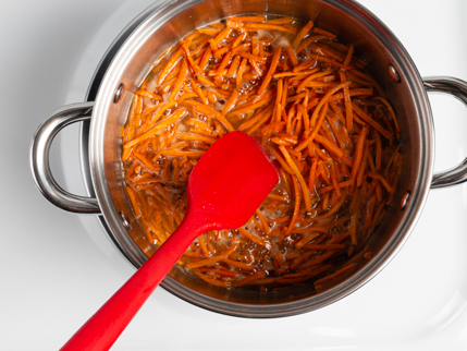  Remuer les carottes râpées dans une casserole avec l’eau, le beurre fondu et le sucre