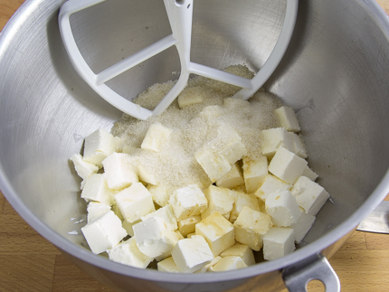Cubes de fromage à la crème et sucre dans le bol d’un batteur sur socle