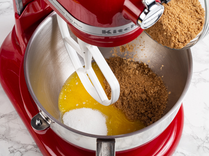 Ajouter la cassonade au bol du batteur sur socle rempli de beurre fondu et de sucre granulé