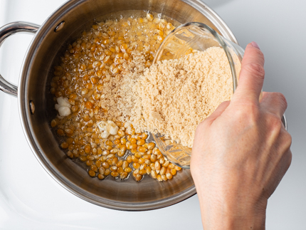Verser la cassonade dorée dans une casserole avec de l’huile et des grains de maïs