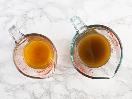 Deux tasses à mesurer, une pâle et une foncée, remplies de thé