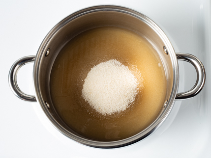 Le sucre qui commence à fondre dans une casserole sur une cuisinière