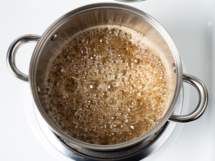  Le sucre qui commence à bouillir dans une casserole sur une cuisinière