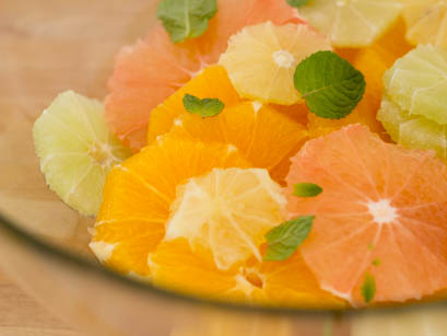Orange , ginger and mint mixed in a bowl