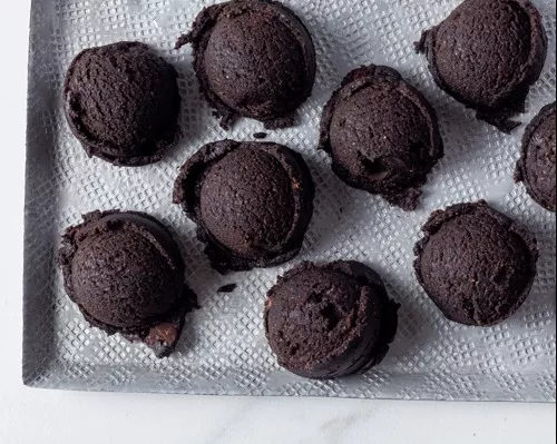 Dix boules de pâte à biscuits au chocolat noir sur un plateau blanc