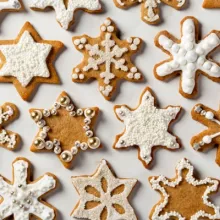 Biscuits au mélange à pain d’épices en forme d’étoiles et de flocons de neige, décorés de glaçage royal et de confettis