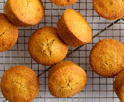 Muffins à la semoule de maïs sur une grille de refroidissement avec un tissu vert pâle