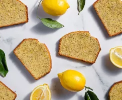 Tranches de gâteau quatre-quarts sur un plateau avec un couteau, des feuilles et un citron