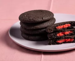 Piles de biscuits au chocolat noir farcis de pâte d’amande rouge