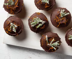 Rangées de cupcakes garnis de glaçage à la ganache, zeste d’orange et romarin givré