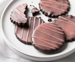 Assiette de biscuits au chocolat recouverts d’une laque rose foncée