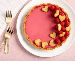 Tarte panna cotta framboises et eau de rose décorée de framboises et de biscuits en forme de cœur