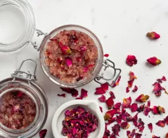 Pots d’exfoliant au sucre biologique et à l’eau de rose avec des pétales