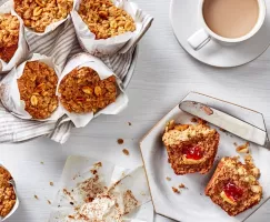 Des muffins végétaliens au beurre d'arachide et à la confiture sur une table de petit-déjeuner, certains enveloppés dans du papi
