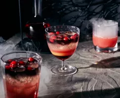 Cocktail de vodka noire et de canneberge sur un fond effrayant avec fumée tourbillonnante.